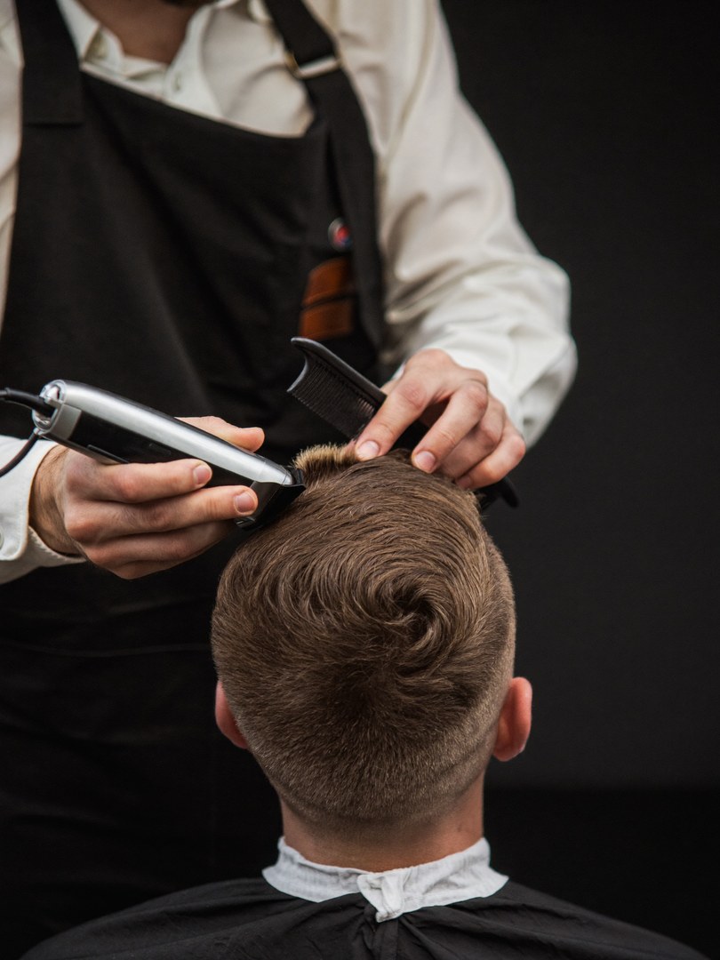 Barber cutting a client's hair at Boldline Barber Co.