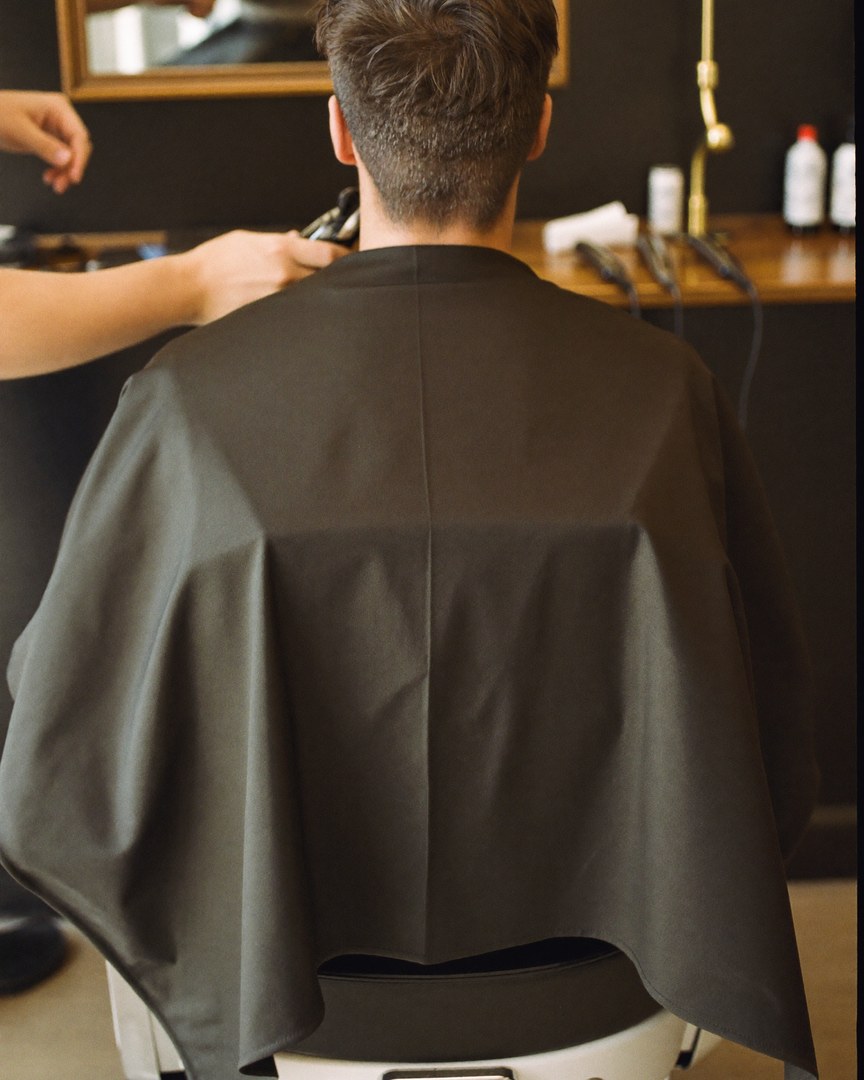 Barber with a young client outside the shop