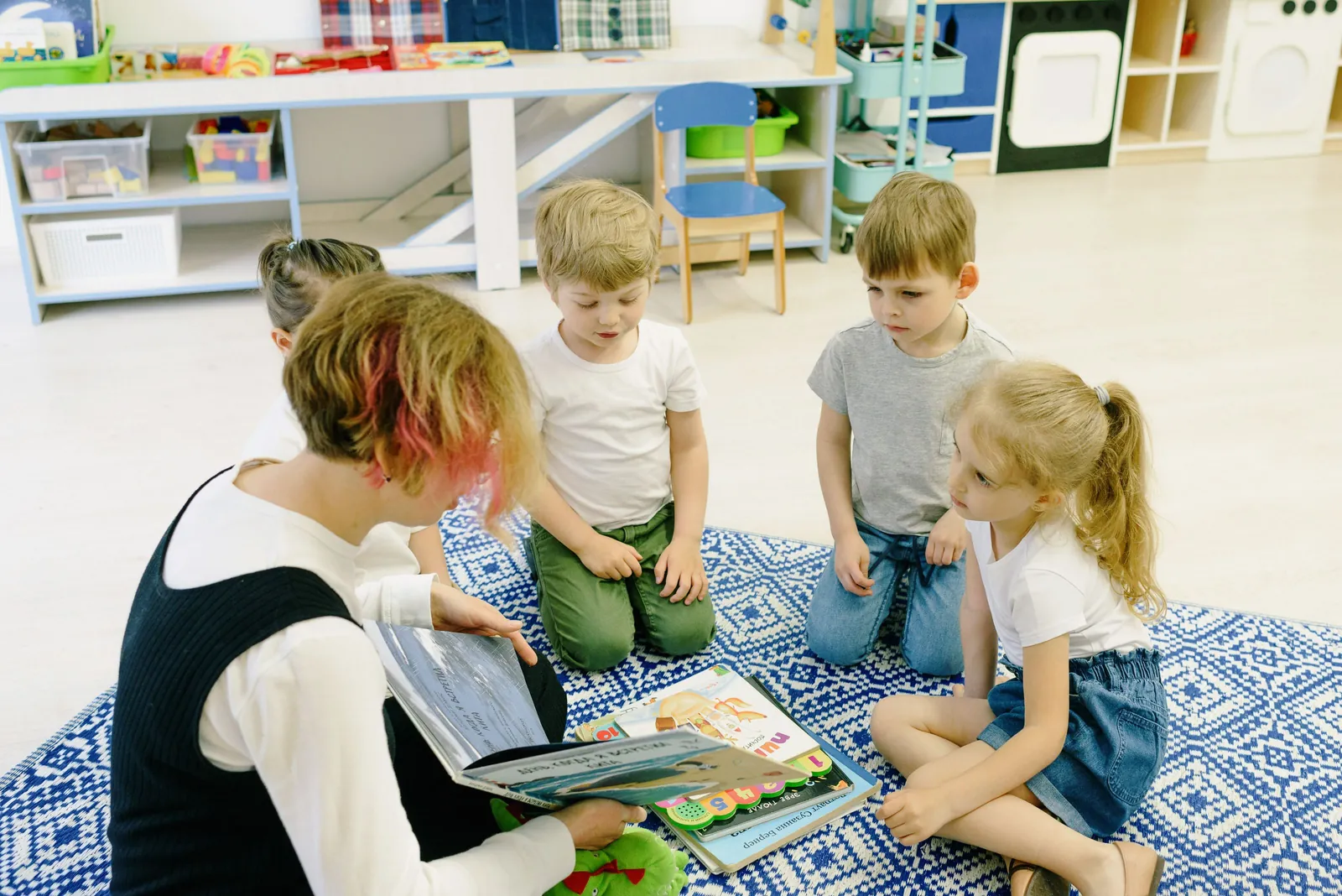 Teacher reading a story to preschoolers on the rug